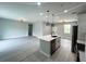 Expansive open floor plan with sleek flooring, modern lighting, and a kitchen with an island and stainless appliances at 3045 Montgomery Dr, Port Charlotte, FL 33981