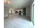 Bright, open-concept living area featuring modern light fixtures and light gray wood-look flooring at 3045 Montgomery Dr, Port Charlotte, FL 33981