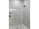 Walk-in shower with elegant marble tile and black fixtures, including a rainfall shower head at 3045 Montgomery Dr, Port Charlotte, FL 33981