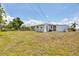 Expansive backyard featuring a well-maintained lawn and a charming single-story home at 330 Lasayette Ne Dr, Port Charlotte, FL 33952