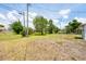 Large backyard with trees and grass with potential for creating a great outdoor space at 330 Lasayette Ne Dr, Port Charlotte, FL 33952