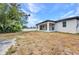 Exterior view of the home with a spacious backyard, and a covered patio at 3380 Elkcam Blvd, Port Charlotte, FL 33952