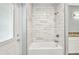 Bright bathroom featuring a tub with a marble tile surround and vanity with granite countertop at 3380 Elkcam Blvd, Port Charlotte, FL 33952
