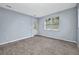 A room with gray walls, white trim, and a door and window, and wood-look floors at 3380 Elkcam Blvd, Port Charlotte, FL 33952