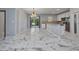 Open-concept kitchen and dining area featuring stylish marble floors and modern light fixtures at 3380 Elkcam Blvd, Port Charlotte, FL 33952