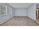 A spacious living room with wood laminate flooring and natural light from two windows at 3380 Elkcam Blvd, Port Charlotte, FL 33952