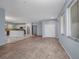 Open-concept living room with wood laminate flooring and transitions to a modern kitchen at 3380 Elkcam Blvd, Port Charlotte, FL 33952