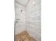 A shower with white marbled tile walls and pebble floor at 3380 Elkcam Blvd, Port Charlotte, FL 33952