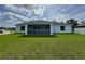 Rear view of the home showcases a beautiful backyard and screened in patio area at 3560 Elias Cir, North Port, FL 34288