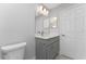 Bathroom featuring gray cabinets, white countertop, a sink, and a framed mirror with vanity lighting at 3560 Elias Cir, North Port, FL 34288