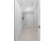 A hallway featuring modern flooring, neutral paint, and access to the laundry room for added convenience at 3560 Elias Cir, North Port, FL 34288