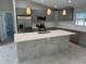 Bright kitchen features gray cabinets, quartz countertops, stainless appliances, and center island with sink at 3560 Elias Cir, North Port, FL 34288