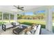 This screen enclosed patio has two chairs, a couch, and a view to the backyard at 3560 Elias Cir, North Port, FL 34288