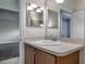 Bathroom with a vanity featuring a white sink and wood cabinets, complemented by a large mirror at 3702 Lakewood Blvd, North Port, FL 34287