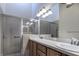 Modern bathroom featuring double sinks, a spacious shower, and a large, lighted mirror at 3702 Lakewood Blvd, North Port, FL 34287