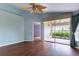 Bright bedroom featuring a ceiling fan, wood floors, and a sliding glass door to the screened in patio at 3702 Lakewood Blvd, North Port, FL 34287