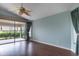 Bright bedroom featuring a ceiling fan, wood floors, and a sliding glass door to the screened in patio at 3702 Lakewood Blvd, North Port, FL 34287