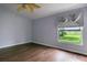 Light-filled bedroom with wood floors, ceiling fan and large window overlooking the yard at 3702 Lakewood Blvd, North Port, FL 34287
