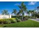 Landscaped entrance to Villas of Sabal Trace II with lush foliage and a clear blue sky at 3702 Lakewood Blvd, North Port, FL 34287
