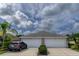 Charming home with a two-car garage, well-maintained landscaping, and a lovely sky at 3702 Lakewood Blvd, North Port, FL 34287