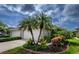 Charming home exterior featuring lush landscaping and a well-manicured lawn at 3702 Lakewood Blvd, North Port, FL 34287