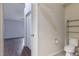 Half bathroom featuring a toilet and metal shelving, with a bedroom visible through a doorway at 3702 Lakewood Blvd, North Port, FL 34287