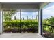 Enclosed lanai with screen windows, showcasing a lush green landscape with palm trees at 3702 Lakewood Blvd, North Port, FL 34287
