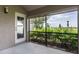 Enclosed lanai with screen windows, showcasing lush green landscape and a doorway to the exterior at 3702 Lakewood Blvd, North Port, FL 34287