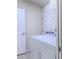 Well-lit laundry room with white washer and dryer, and a convenient storage shelf at 3702 Lakewood Blvd, North Port, FL 34287