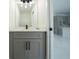Modern bathroom featuring gray vanity, matte black plumbing fixtures, and view into the kitchen at 3920 Wisteria Pl, Punta Gorda, FL 33950