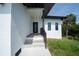 Stylish home entrance with modern door, stucco siding, and neat landscaping at 3920 Wisteria Pl, Punta Gorda, FL 33950