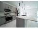 Contemporary kitchen featuring stainless steel appliances, grey cabinetry, and a large island at 3920 Wisteria Pl, Punta Gorda, FL 33950