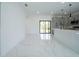 Open-concept living space with marble floors, flowing to kitchen and featuring sliding glass doors to backyard at 3920 Wisteria Pl, Punta Gorda, FL 33950