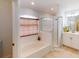 Bathroom features a soaking tub with a shower, tile floors, and natural light from a window at 4027 Quaker Ln, North Port, FL 34288