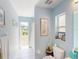 Bright bathroom featuring blue walls, a walk-in shower, and a window with a view of the backyard at 4027 Quaker Ln, North Port, FL 34288