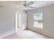 This bedroom has neutral walls, a ceiling fan, and a window overlooking the backyard at 4027 Quaker Ln, North Port, FL 34288