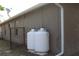 View of the house exterior showcasing two propane tanks by the exterior wall near a fence at 4027 Quaker Ln, North Port, FL 34288