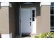Close up of the front door with decorative trim and sidelight windows at 4027 Quaker Ln, North Port, FL 34288