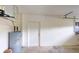 A clean, bright garage space featuring a white door, water heater, and ample room for storage at 4027 Quaker Ln, North Port, FL 34288