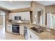 Modern kitchen with granite counters, stainless appliances, and white cabinets at 4027 Quaker Ln, North Port, FL 34288
