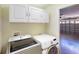 Convenient laundry room area features modern appliances, white cabinetry, and access to the garage at 4027 Quaker Ln, North Port, FL 34288