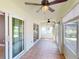 Enclosed sunroom with sliding glass doors, windows, and ceiling fans at 4027 Quaker Ln, North Port, FL 34288