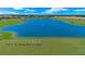 Scenic aerial view of a lake surrounded by a golf course and residential buildings in a vibrant community at 43030 Greenway Blvd # 426, Punta Gorda, FL 33982