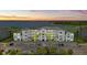 Aerial view of condo and golf course community with lake at sunset at 43030 Greenway Blvd # 426, Punta Gorda, FL 33982