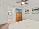 Bright bedroom featuring a walk-in bathroom and a large TV on a wooden dresser at 43030 Greenway Blvd # 426, Punta Gorda, FL 33982