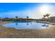Beautiful community pool with lounge chairs, umbrellas, and palm trees for relaxation under the bright sunny sky at 43030 Greenway Blvd # 426, Punta Gorda, FL 33982