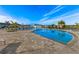 Community pool featuring an oversized deck with ample seating under sun umbrellas, and plenty of palm trees in the background at 43030 Greenway Blvd # 426, Punta Gorda, FL 33982