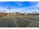 Community tennis court with a blue shelter for shade, surrounded by palm trees on a sunny day at 43030 Greenway Blvd # 426, Punta Gorda, FL 33982