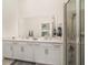 Well-lit bathroom with double vanity, large mirror, and glass-enclosed shower at 43984 Boardwalk Loop # 1726, Punta Gorda, FL 33982