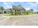Elegant entrance with lush landscaping, a circular driveway, and a grand porte-cochère at 43984 Boardwalk Loop # 1726, Punta Gorda, FL 33982